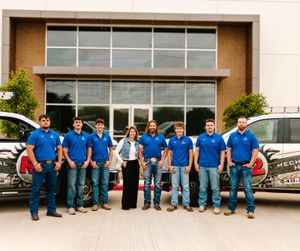 The R2 Mechanical HVAC team standing with their service trucks outside the shop in Krum, Texas