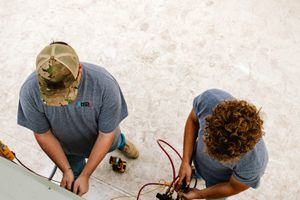 R2 technician running diagnostics on a rooftop HVAC unit